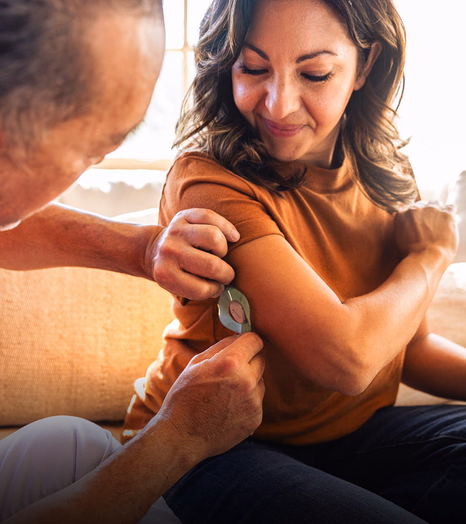 A woman having a CGM device applied to her arm as part of her Verily care program.
