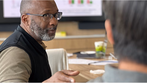 Chief Clinical office Vindell Washington, gesturing while speaking to a colleague in a conference room.